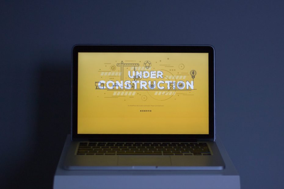 Ein Laptop-Display zeigt eine Animation mit dem Text "Under Construction".